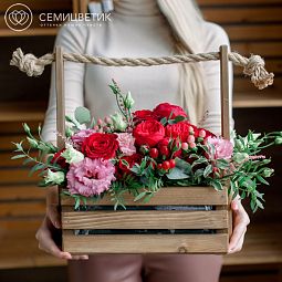 Деревянный ящик с красной пионовидной розой и зеленью